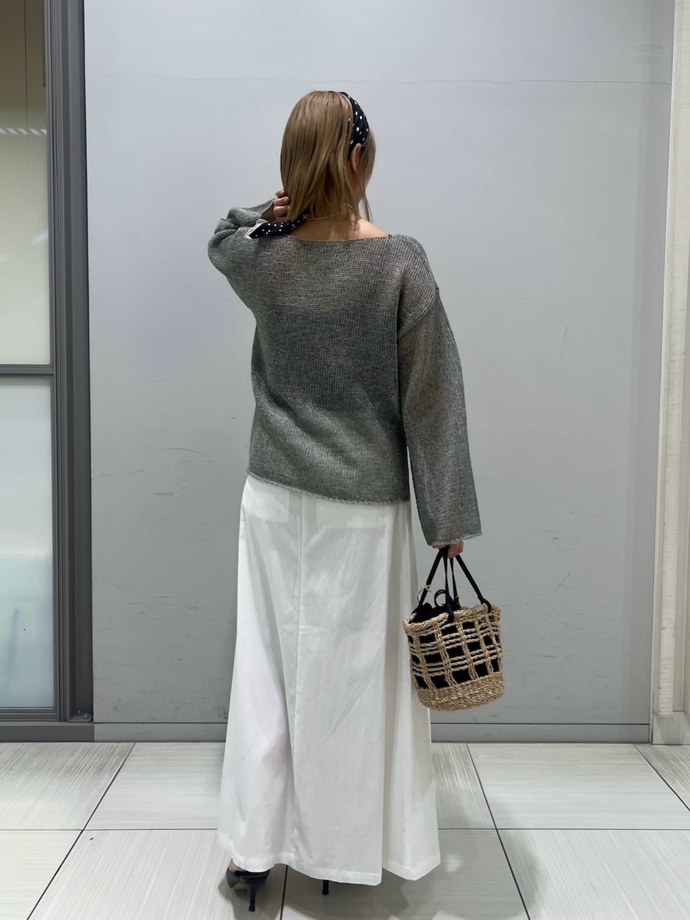 ブラック系のパンプス、グレー系のニット/セーター、ブラウン系のスカートを着用したレディースの春コーディネートの4枚目の写真