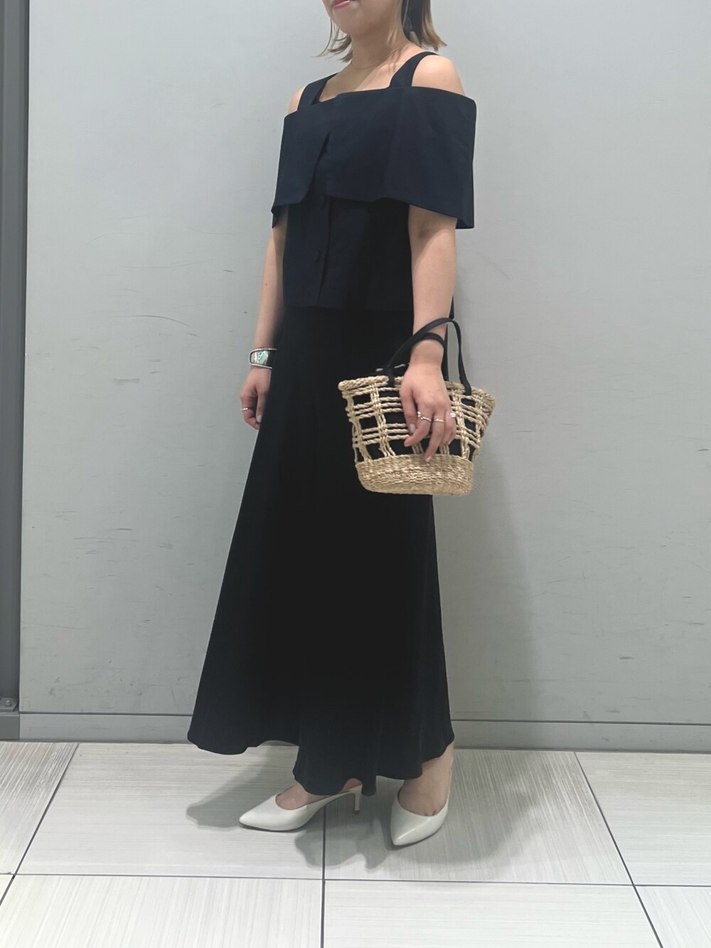 ベージュ系のかごバッグ、ブラック系のシャツ/ブラウス、ブラック系のスカートを着用したレディースの春コーディネートの4枚目の写真
