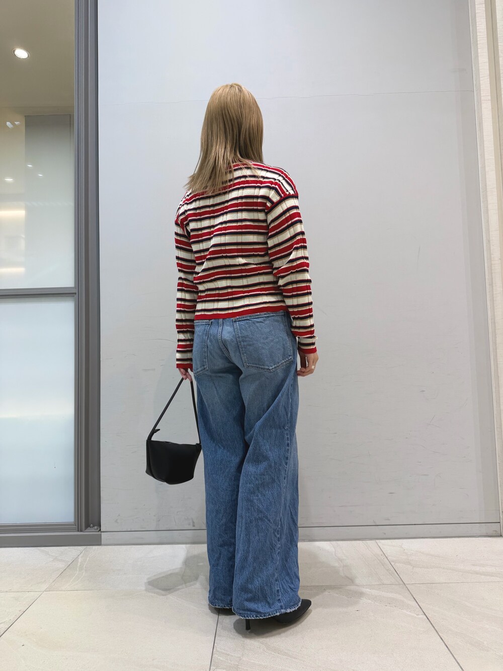 その他のニット/セーター、ブルー系のデニムパンツ、ブラック系のショルダーバッグを着用したレディースの冬コーディネートの6枚目の写真