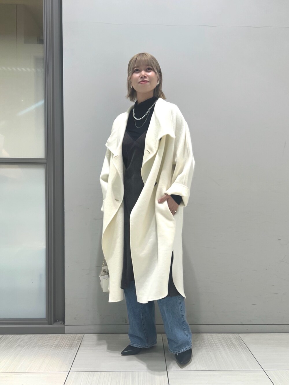 ホワイト系のその他アウター、ブラウン系のワンピース、ホワイト系のショルダーバッグを着用したレディースの冬コーディネートの9枚目の写真