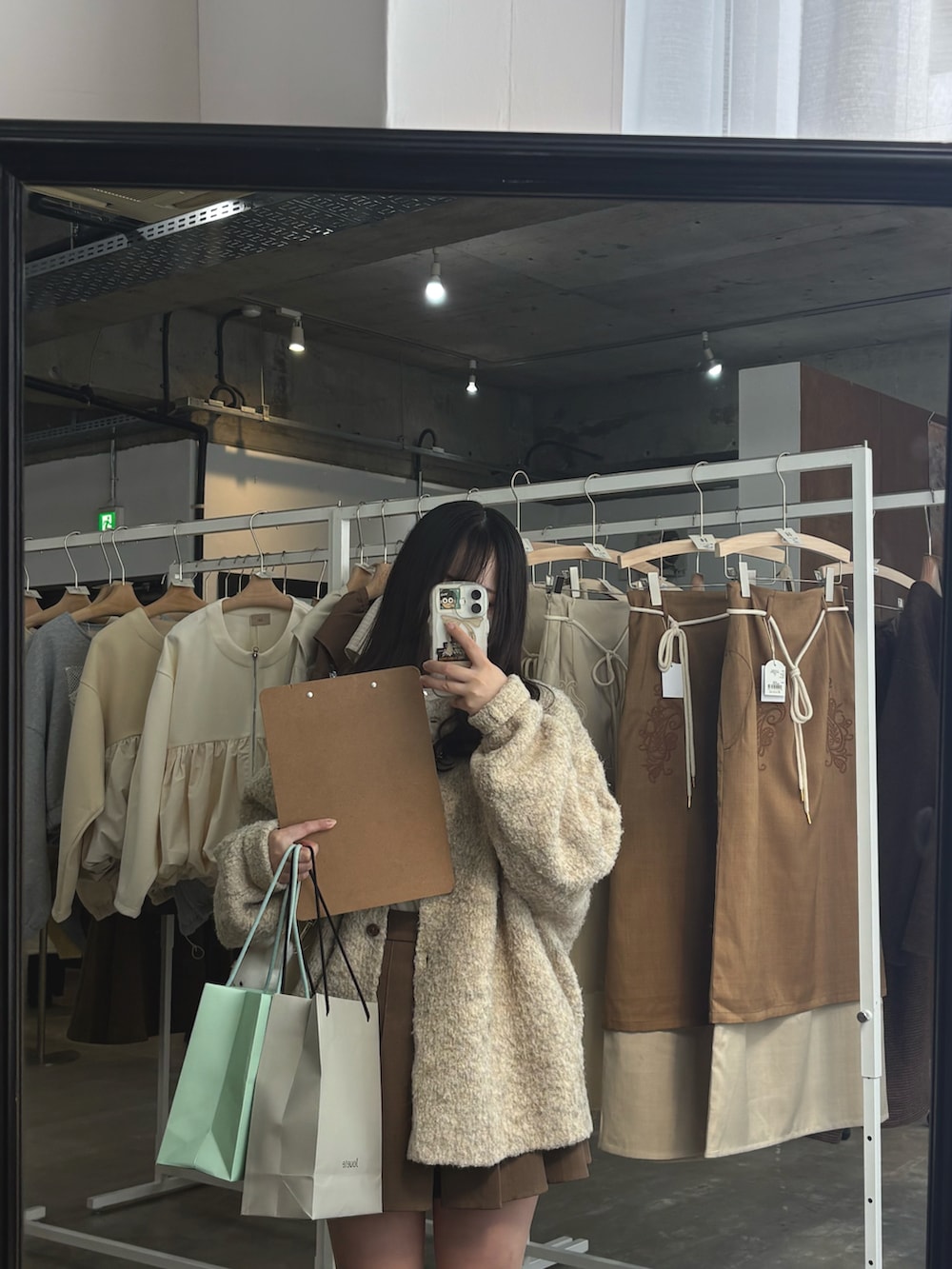 ベージュ系のカーディガン/ボレロ、ホワイト系のシャツ/ブラウス、ホワイト系のショルダーバッグを着用したレディースの秋コーディネートの2枚目の写真