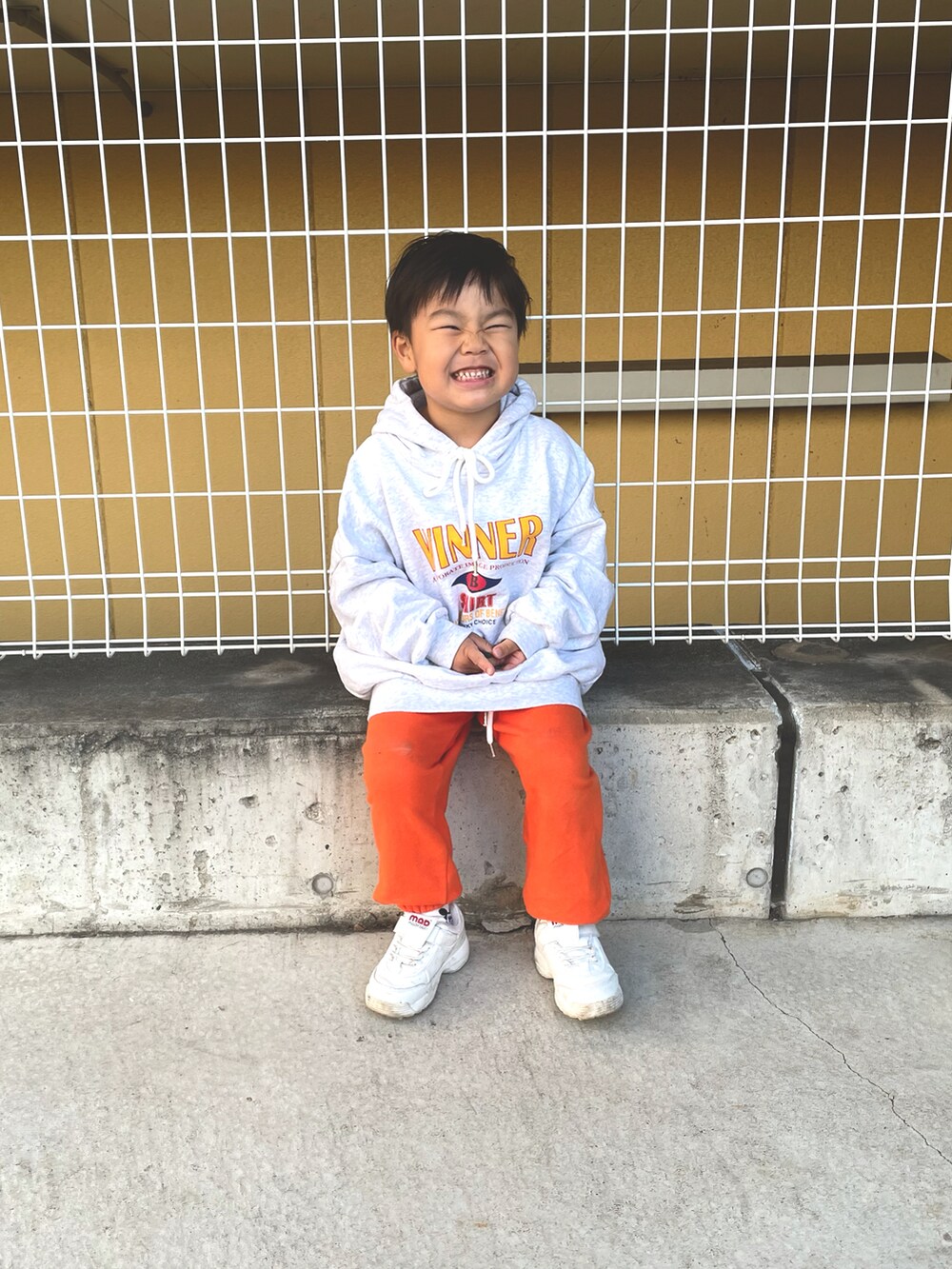 ホワイト系のスニーカーを着用したキッズの秋コーディネートの2枚目の写真