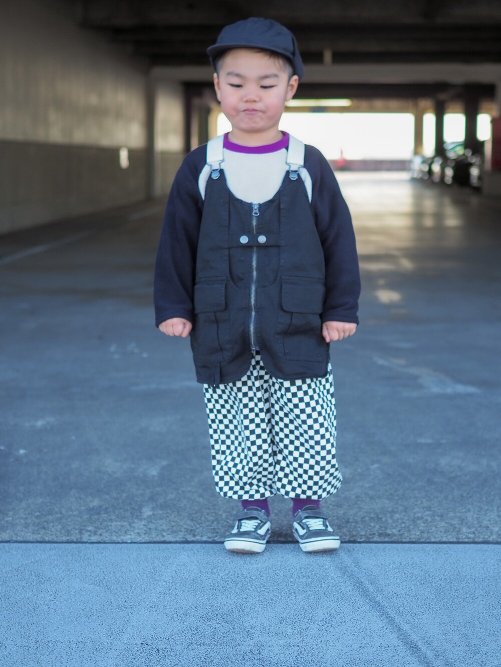 ブラック系のベスト、ブラック系のスニーカーを着用したキッズの冬コーディネートの2枚目の写真