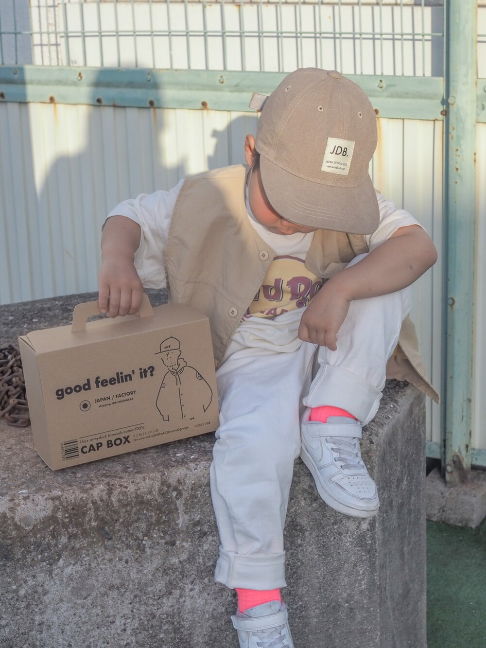 ホワイト系のデニムパンツ、ホワイト系のスニーカー、ベージュ系のキャップを着用したキッズの春コーディネートの2枚目の写真