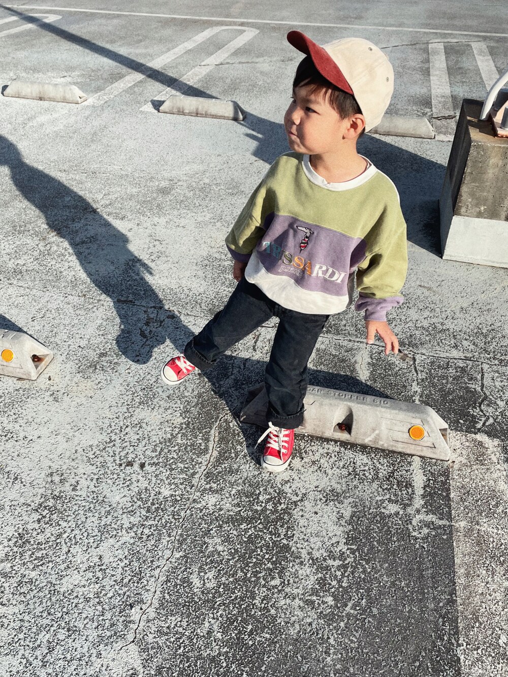 ブラック系のデニムパンツ、レッド系のスニーカーを着用したキッズの秋コーディネートの3枚目の写真