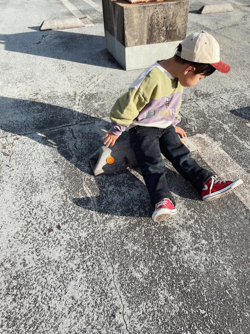 ブラック系のデニムパンツ、レッド系のスニーカーを着用したキッズの秋コーディネートの2枚目の写真