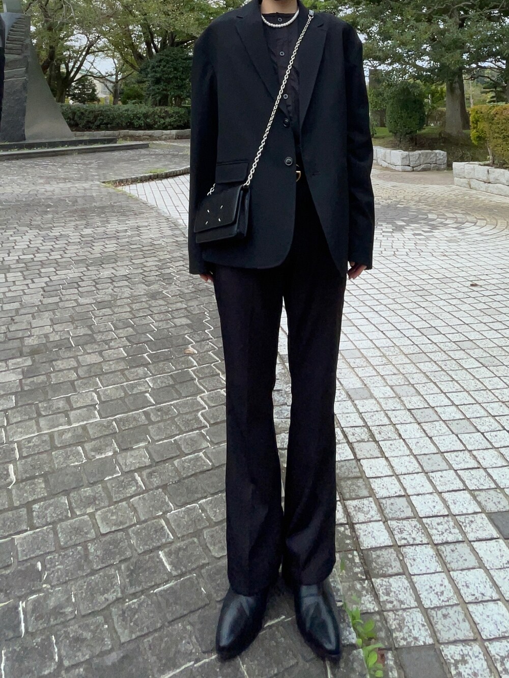 ブラック系のスラックス、ブラック系のブーツ、ブラック系のテーラードジャケットを着用したメンズの秋コーディネートの2枚目の写真