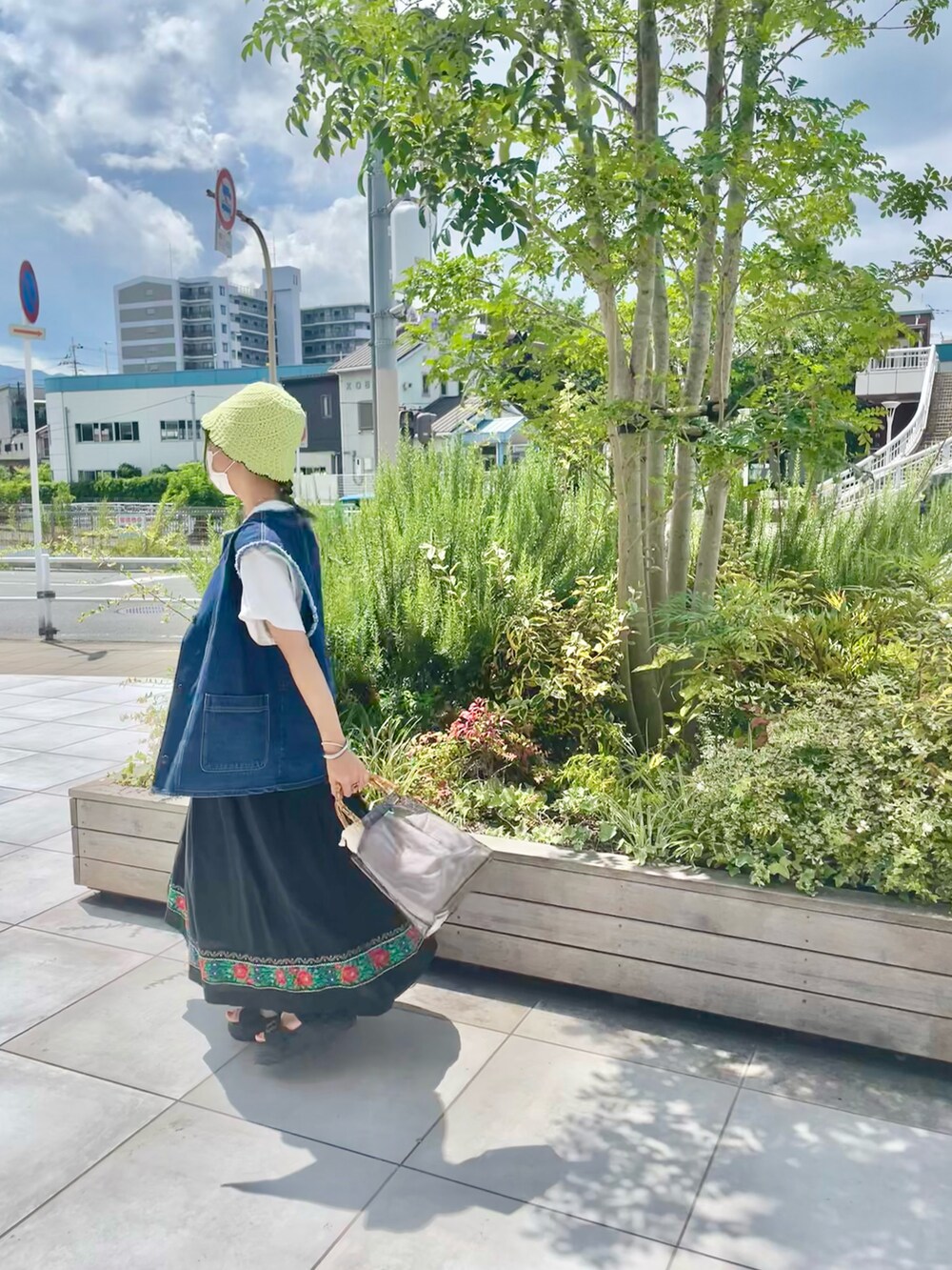 ブラック系のハンドバッグを着用したレディースの夏コーディネートの2枚目の写真