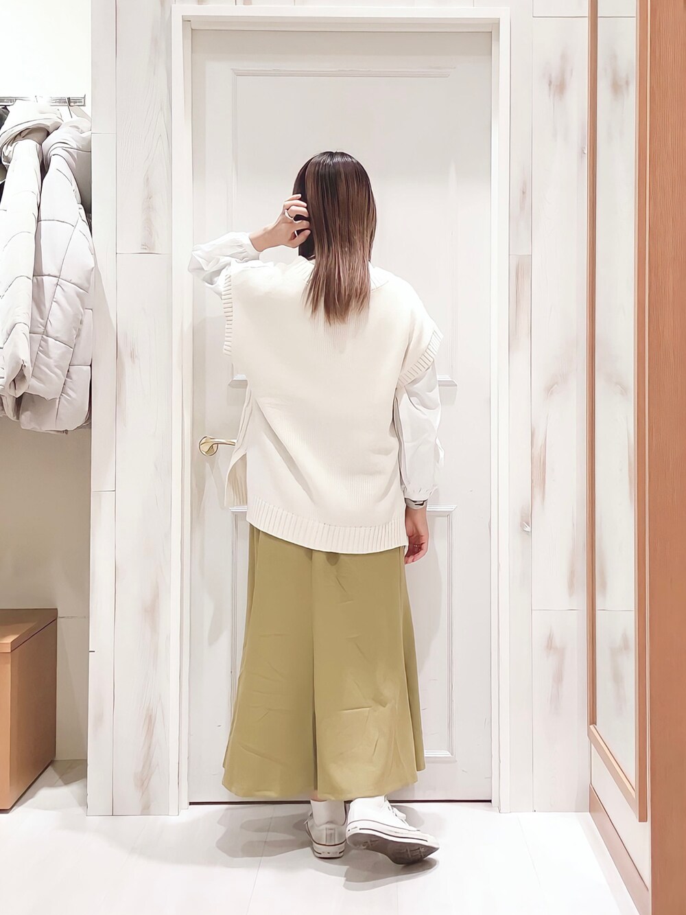 ホワイト系のニット/セーター、ホワイト系のシャツ/ブラウス、イエロー系のスカートを着用したレディースの冬コーディネートの2枚目の写真