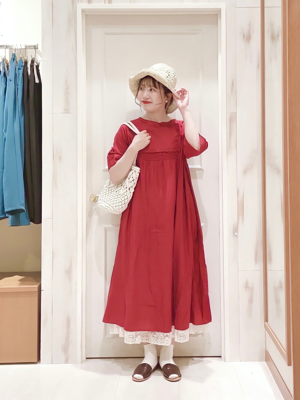 レッド系のワンピース、ホワイト系のスカート、ホワイト系のトートバッグを着用したレディースの春コーディネートの2枚目の写真