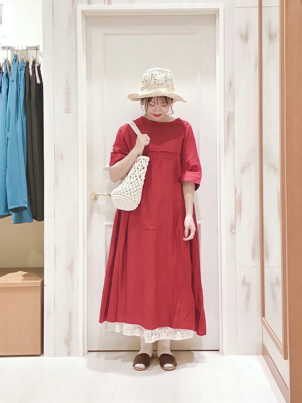 レッド系のワンピース、ホワイト系のスカート、ホワイト系のトートバッグを着用したレディースの春コーディネートの3枚目の写真