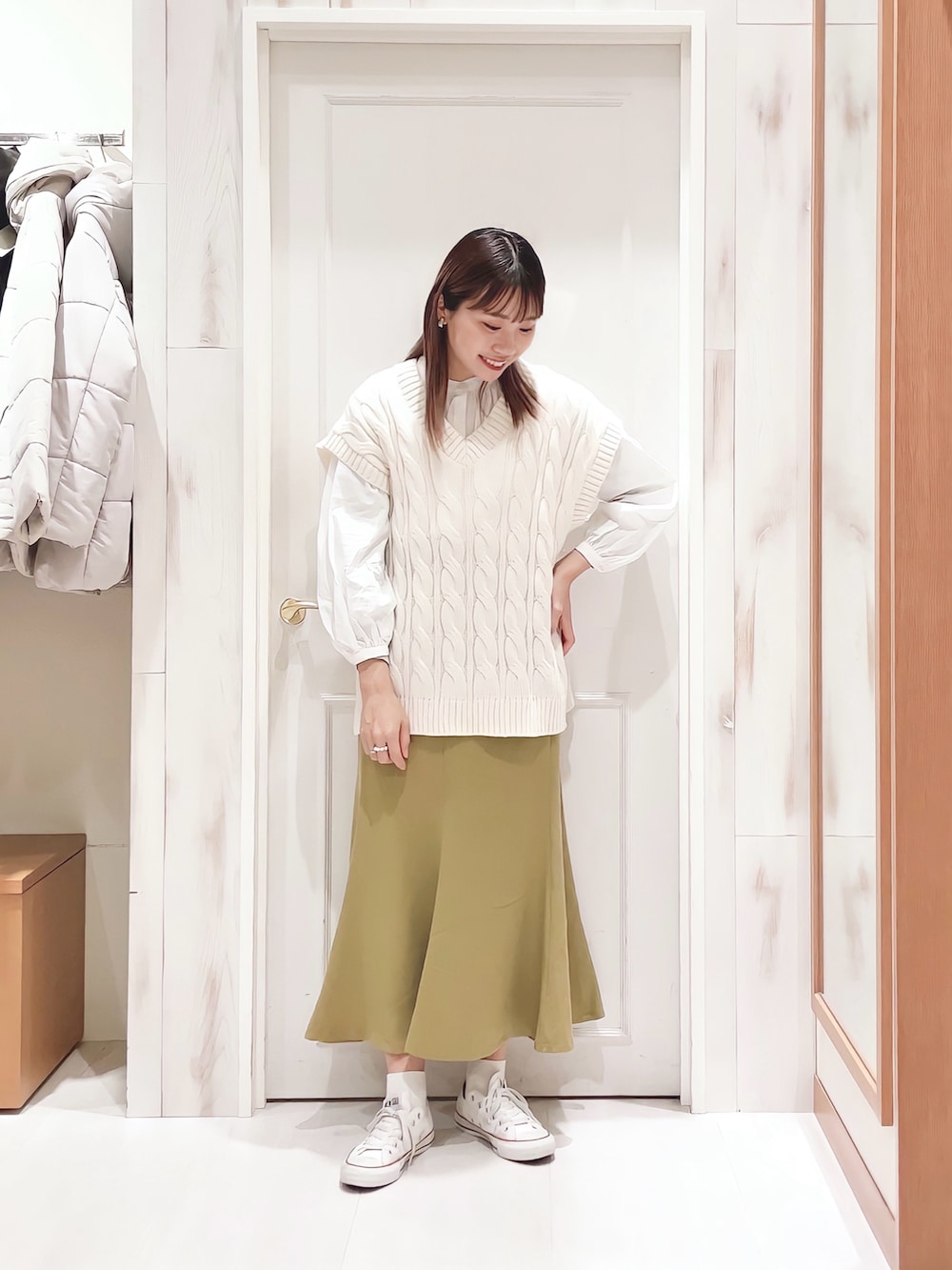 ホワイト系のニット/セーター、ホワイト系のシャツ/ブラウス、イエロー系のスカートを着用したレディースの冬コーディネートの3枚目の写真