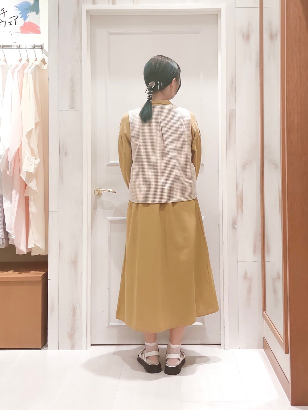 ベージュ系のベスト、イエロー系のワンピース、ベージュ系のトートバッグを着用したレディースの夏コーディネートの2枚目の写真