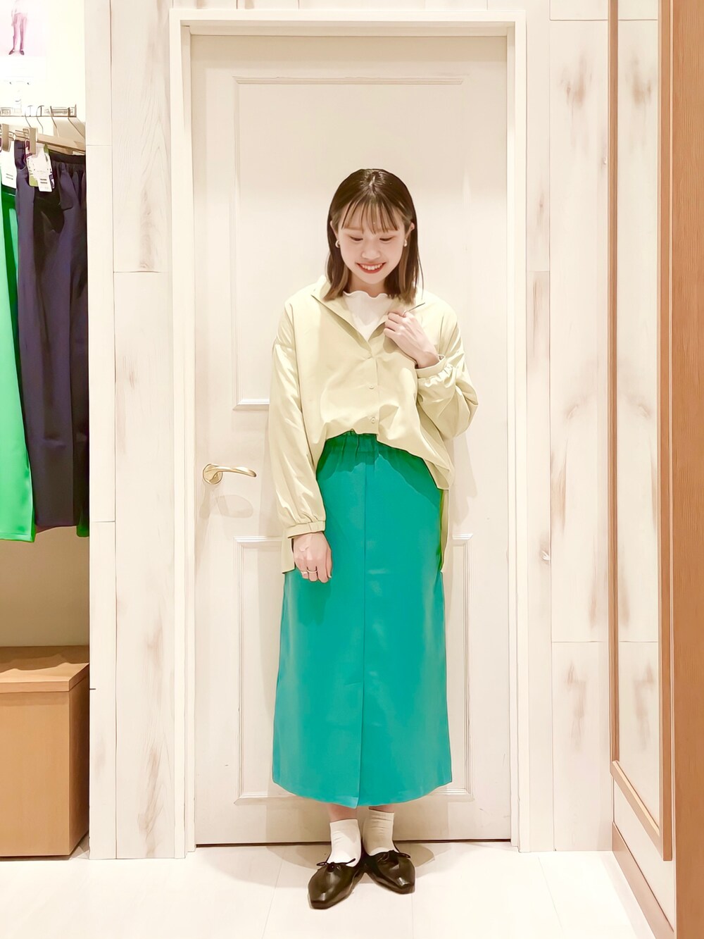 ホワイト系のTシャツ/カットソー、イエロー系のシャツ/ブラウス、グリーン系のスカートを着用したレディースの春コーディネートの2枚目の写真