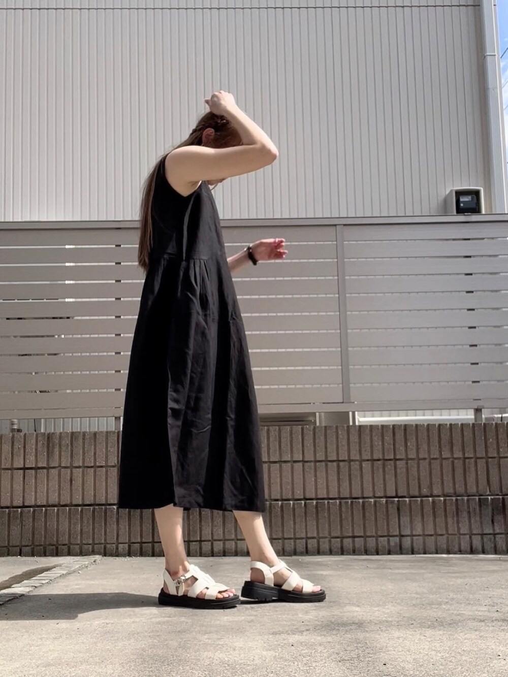 ブラック系のワンピース、ホワイト系のサンダルを着用したレディースの夏コーディネートの3枚目の写真