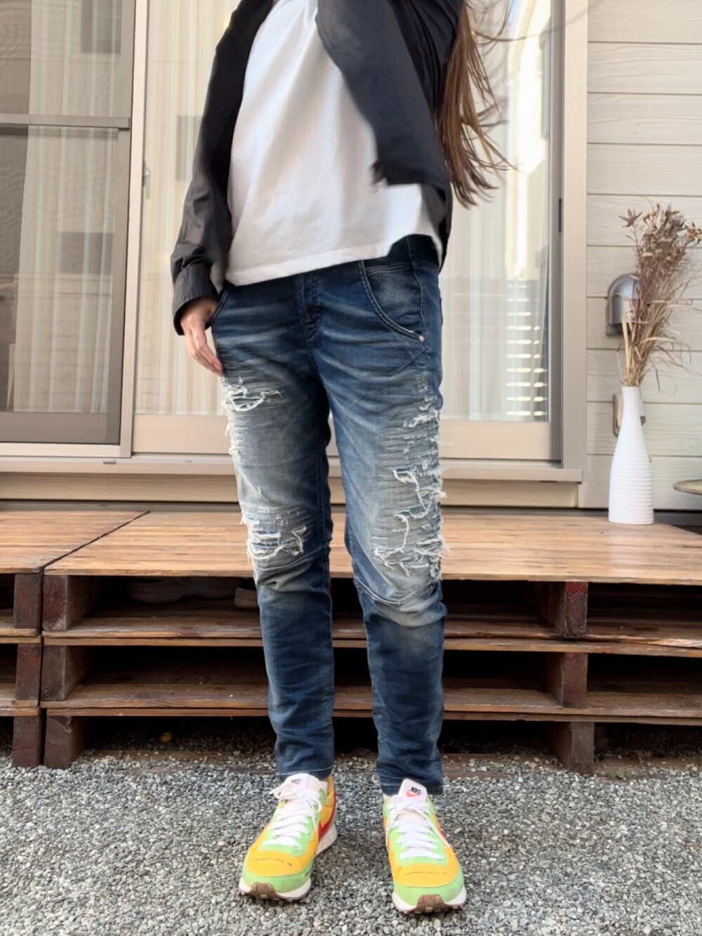 ブラック系のジャケット/アウター、ブルー系のデニムパンツ、イエロー系のスニーカーを着用したレディースの秋コーディネートの3枚目の写真