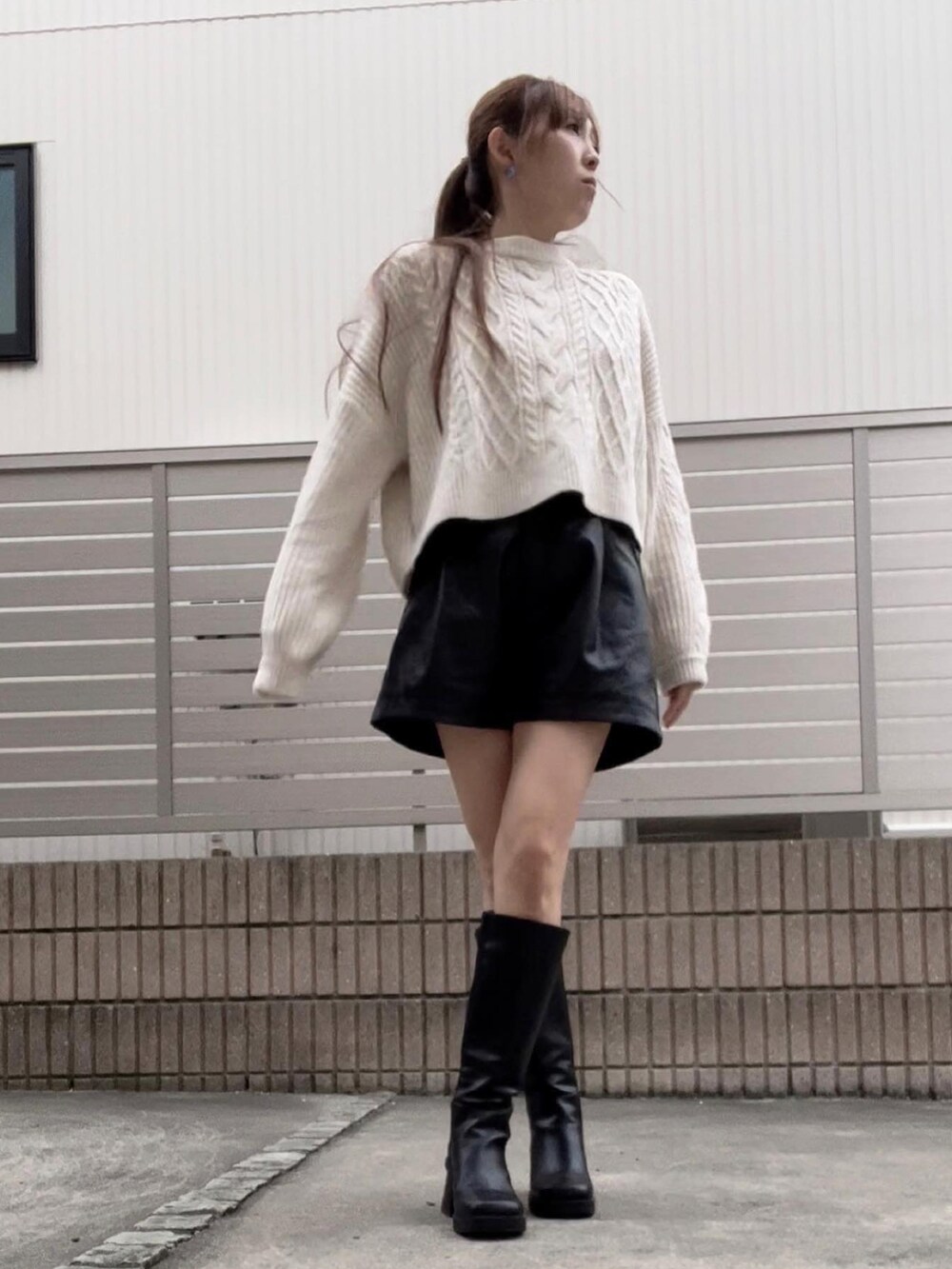 ホワイト系のニット/セーター、ブラック系のその他パンツ、ブラック系のブーツを着用したレディースの冬コーディネートの2枚目の写真