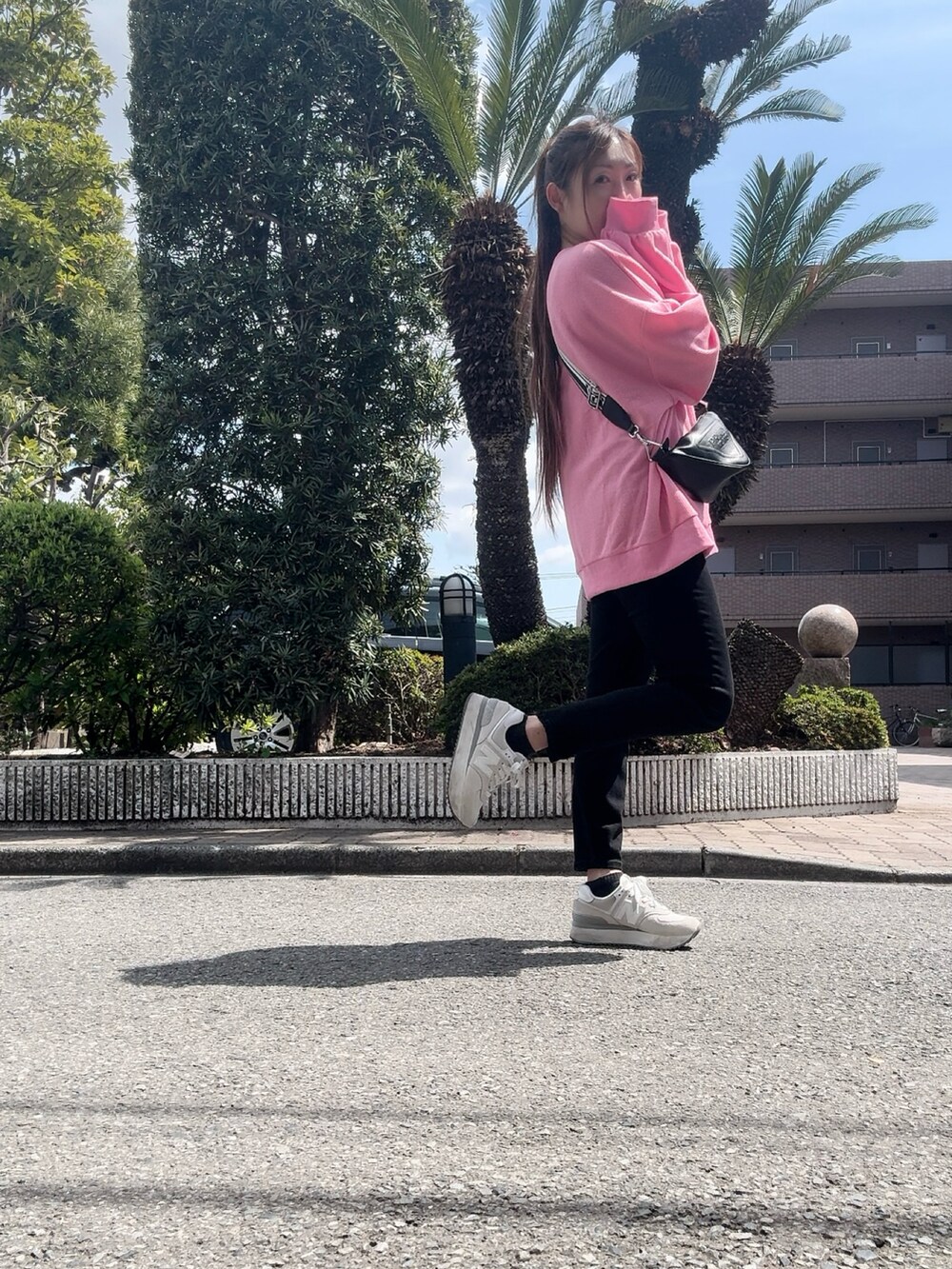 ピンク系のトップスを着用したレディースの春コーディネートの2枚目の写真