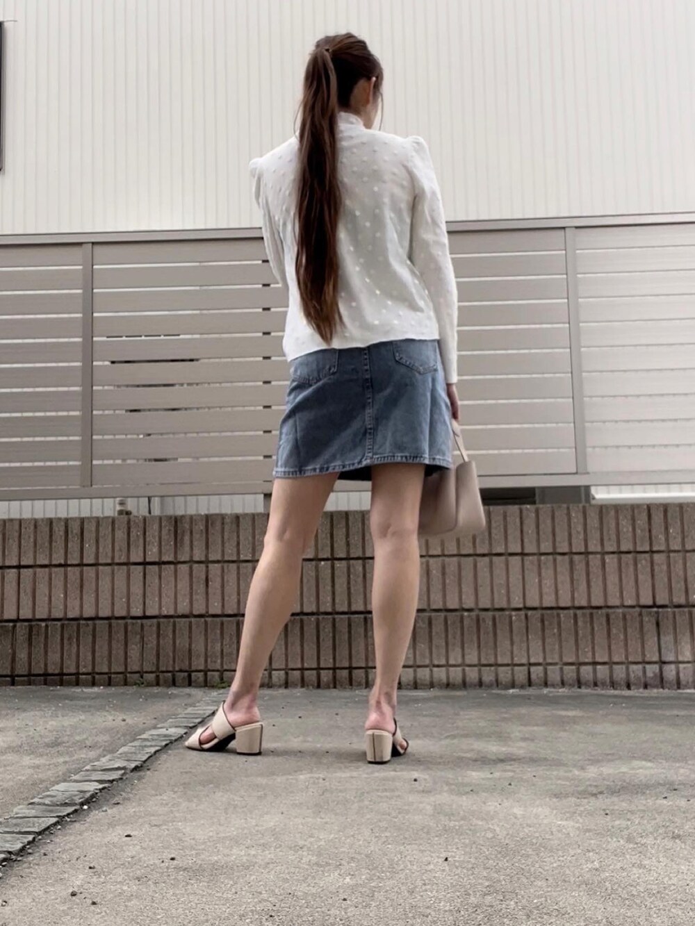 ブルー系のデニムスカート、ホワイト系のシャツ/ブラウスを着用したレディースの春コーディネートの3枚目の写真