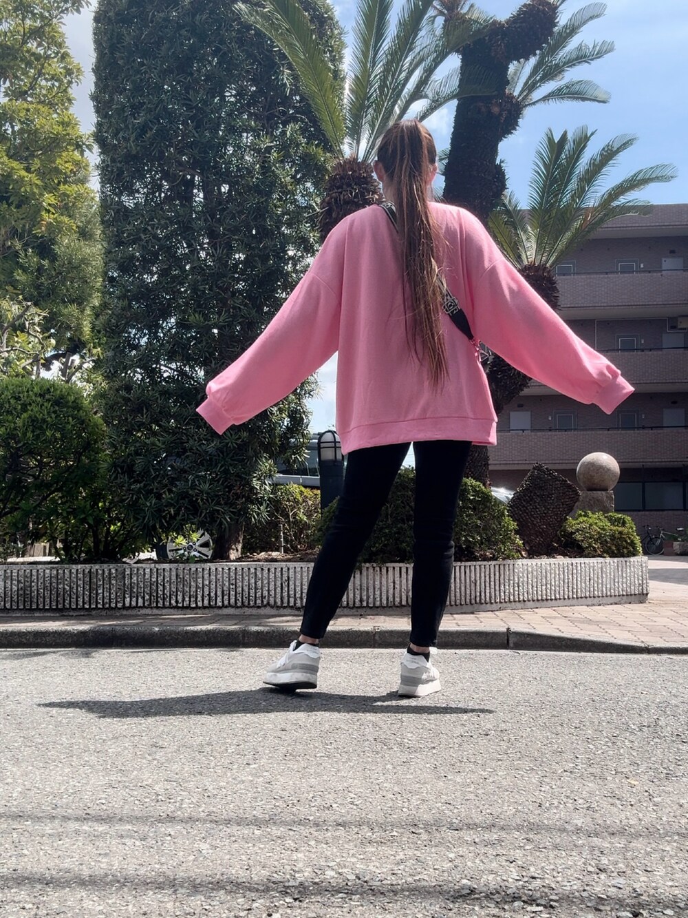 ピンク系のトップスを着用したレディースの春コーディネートの3枚目の写真