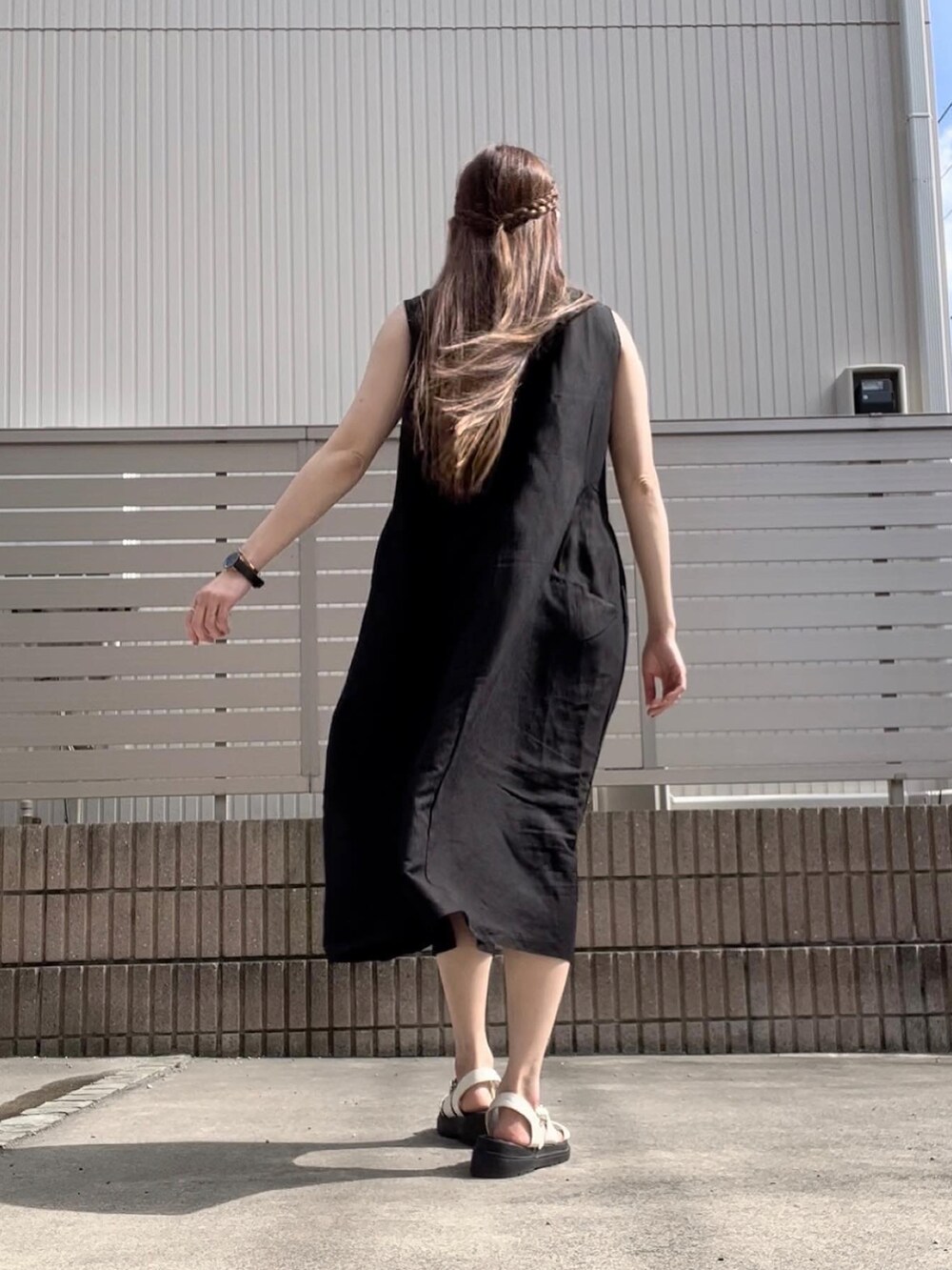 ブラック系のワンピース、ホワイト系のサンダルを着用したレディースの夏コーディネートの2枚目の写真