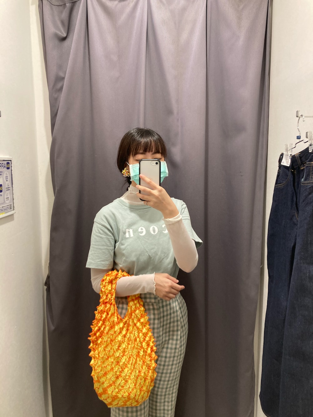 グリーン系のTシャツ/カットソー、オレンジ系のトートバッグ、グリーン系のチノパンツを着用したレディースの秋コーディネートの2枚目の写真