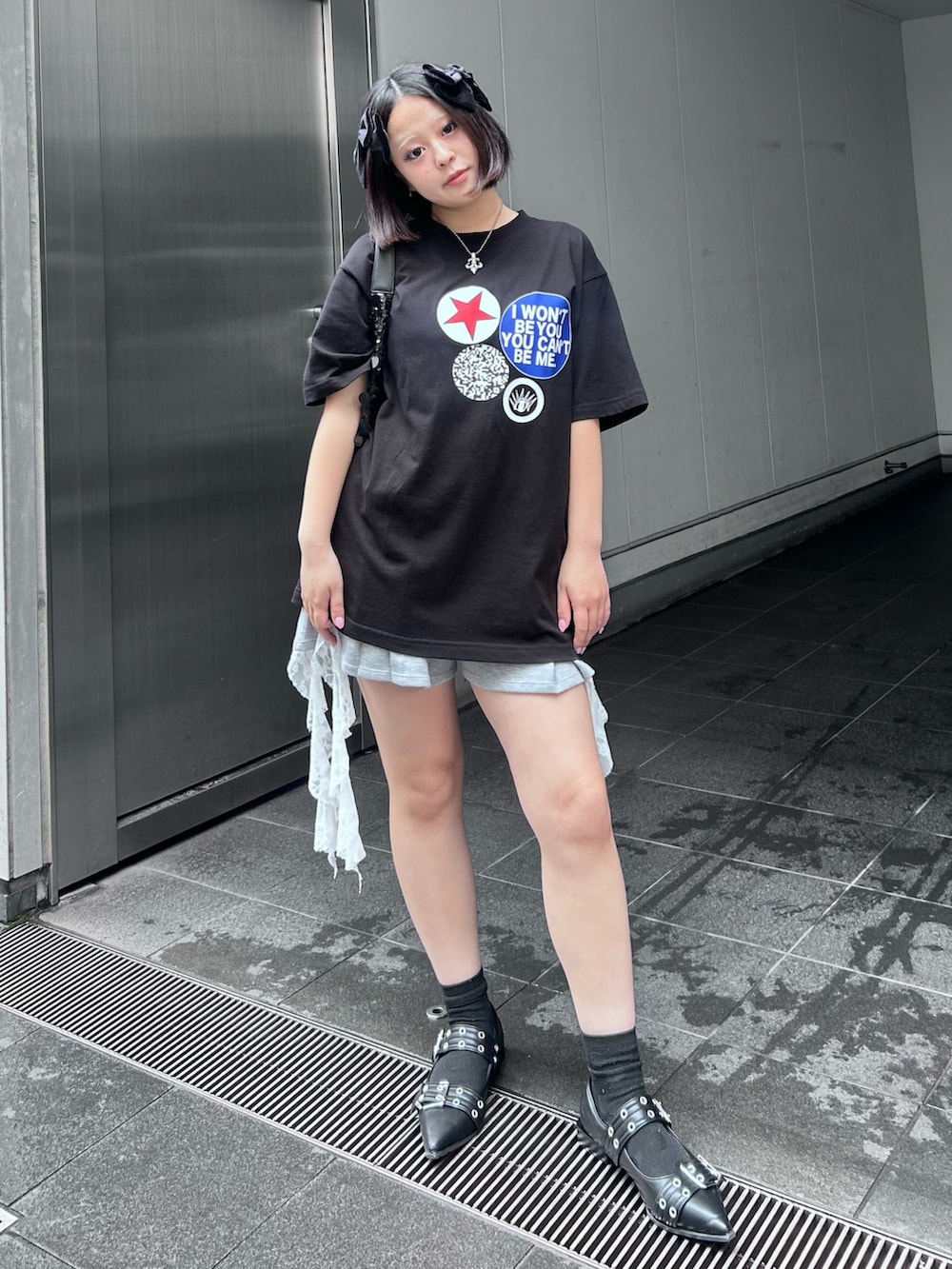 ブラック系のパンプス、ブラック系のハンドバッグ、ホワイト系のキャミソールを着用したレディースの春コーディネートの2枚目の写真