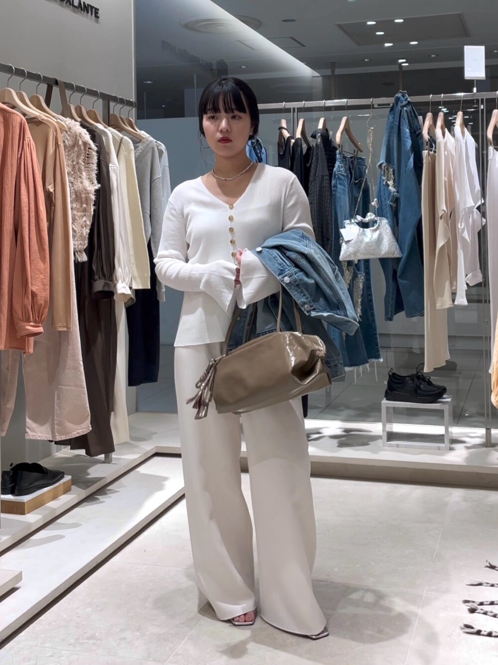 ホワイト系のカーディガン/ボレロ、ホワイト系のその他パンツ、ブラウン系のボストンバッグを着用したレディースの春コーディネートの3枚目の写真