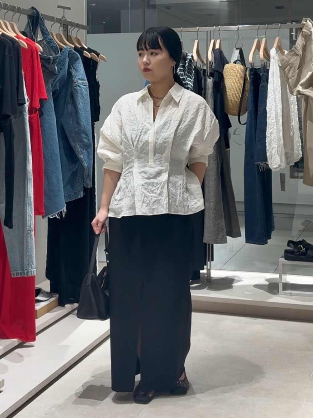 ホワイト系のシャツ/ブラウス、ブラック系のスカート、ブラック系のトートバッグを着用したレディースの春コーディネートの6枚目の写真