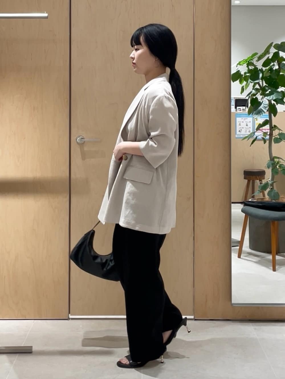 ベージュ系のテーラードジャケット、ホワイト系のTシャツ/カットソー、ブラック系のその他パンツを着用したレディースの春コーディネートの3枚目の写真