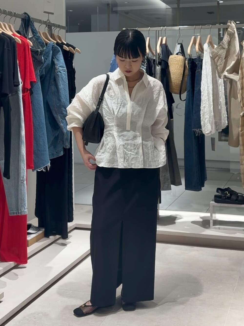 ホワイト系のシャツ/ブラウス、ブラック系のスカート、ブラック系のトートバッグを着用したレディースの春コーディネートの2枚目の写真