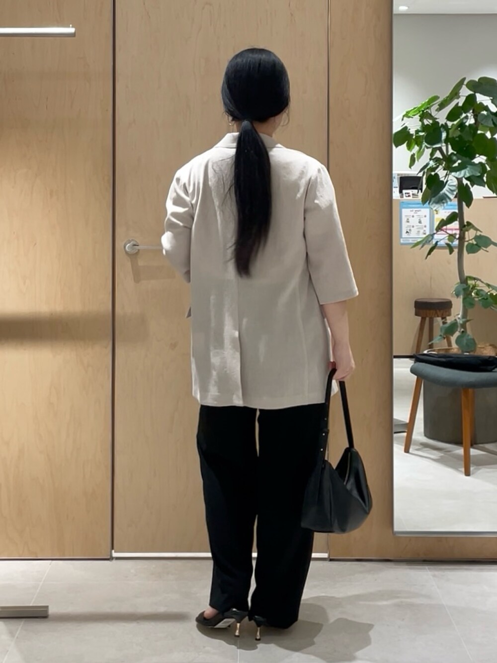 ベージュ系のテーラードジャケット、ホワイト系のTシャツ/カットソー、ブラック系のその他パンツを着用したレディースの春コーディネートの4枚目の写真