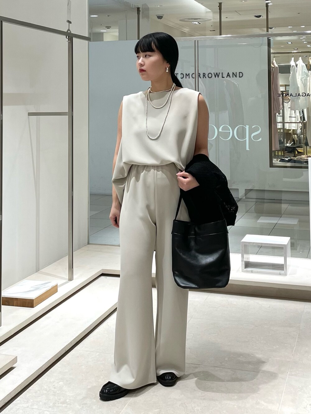 ベージュ系のその他パンツ、ブラック系のトートバッグ、ベージュ系のシャツ/ブラウスを着用したレディースの春コーディネートの7枚目の写真