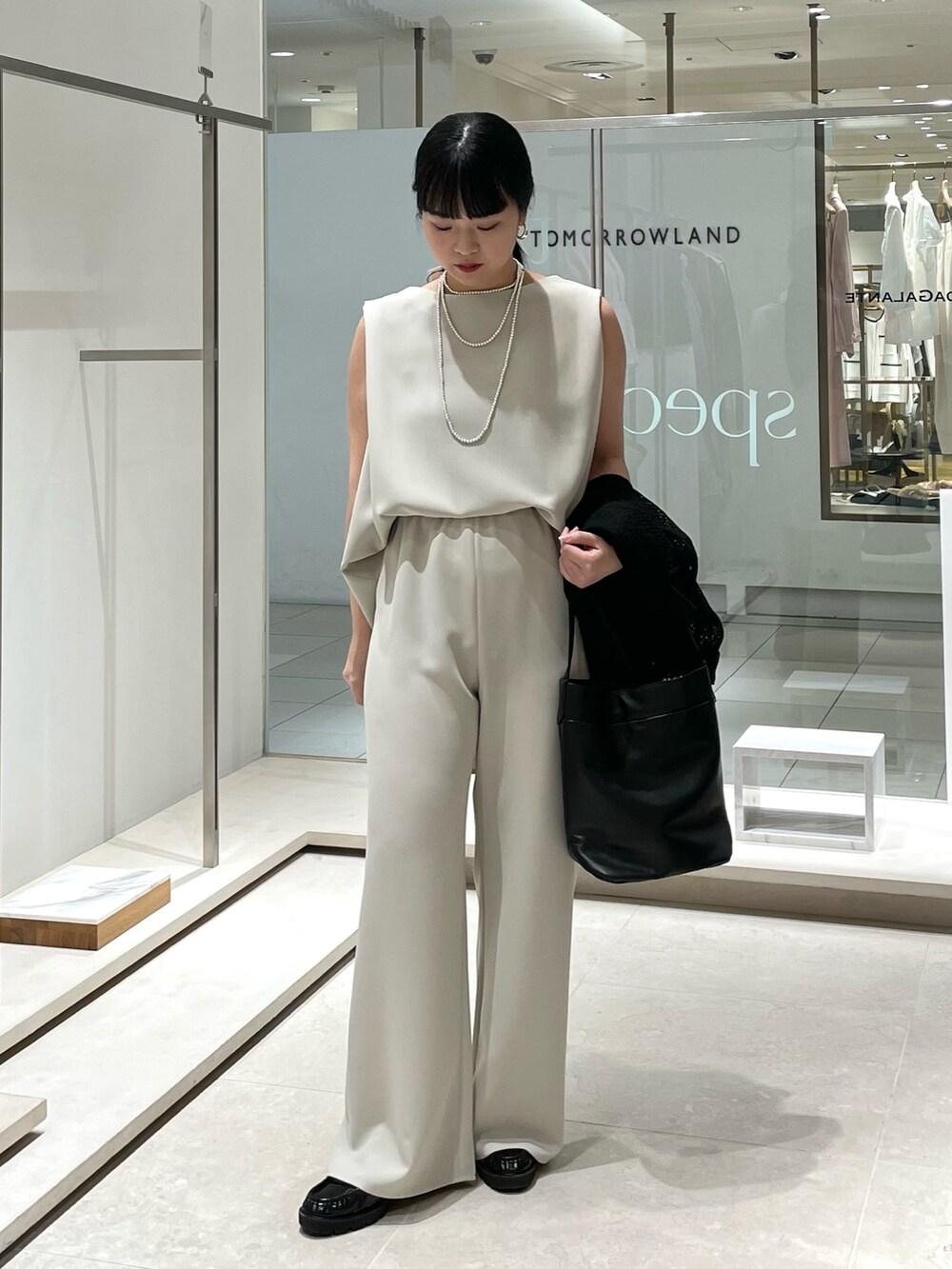 ベージュ系のその他パンツ、ブラック系のトートバッグ、ベージュ系のシャツ/ブラウスを着用したレディースの春コーディネートの6枚目の写真