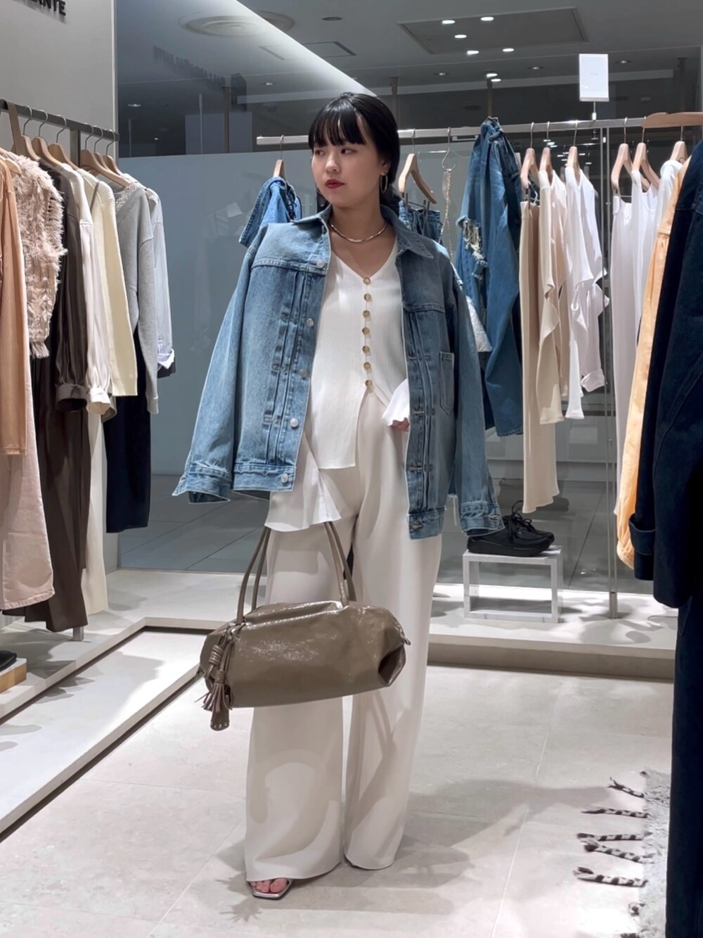 ホワイト系のカーディガン/ボレロ、ホワイト系のその他パンツ、ブラウン系のボストンバッグを着用したレディースの春コーディネートの5枚目の写真