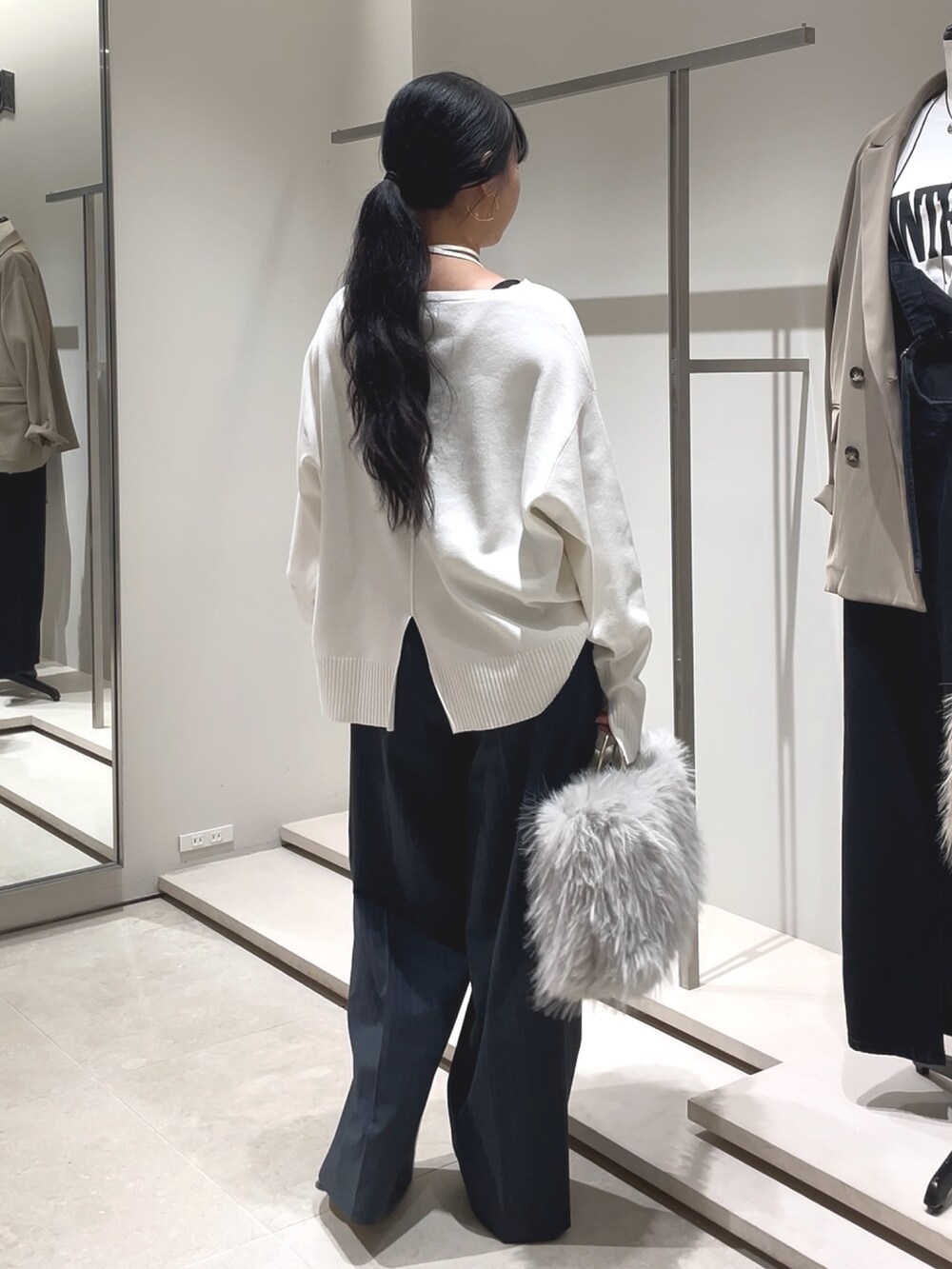 ブルー系のその他パンツ、ホワイト系のニット/セーター、ブラック系のブーツを着用したレディースの秋コーディネートの3枚目の写真
