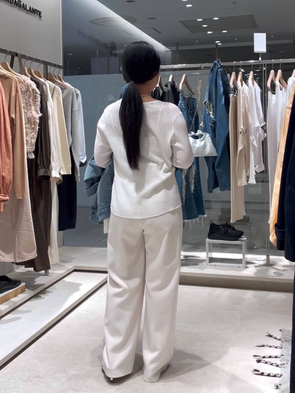 ホワイト系のカーディガン/ボレロ、ホワイト系のその他パンツ、ブラウン系のボストンバッグを着用したレディースの春コーディネートの4枚目の写真
