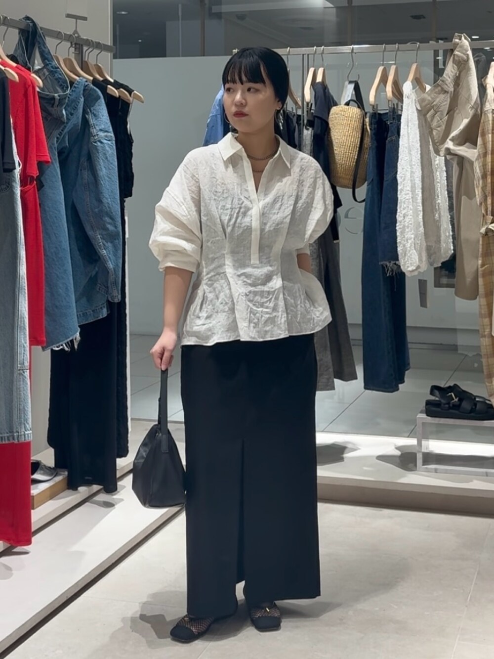 ホワイト系のシャツ/ブラウス、ブラック系のスカート、ブラック系のトートバッグを着用したレディースの春コーディネートの3枚目の写真