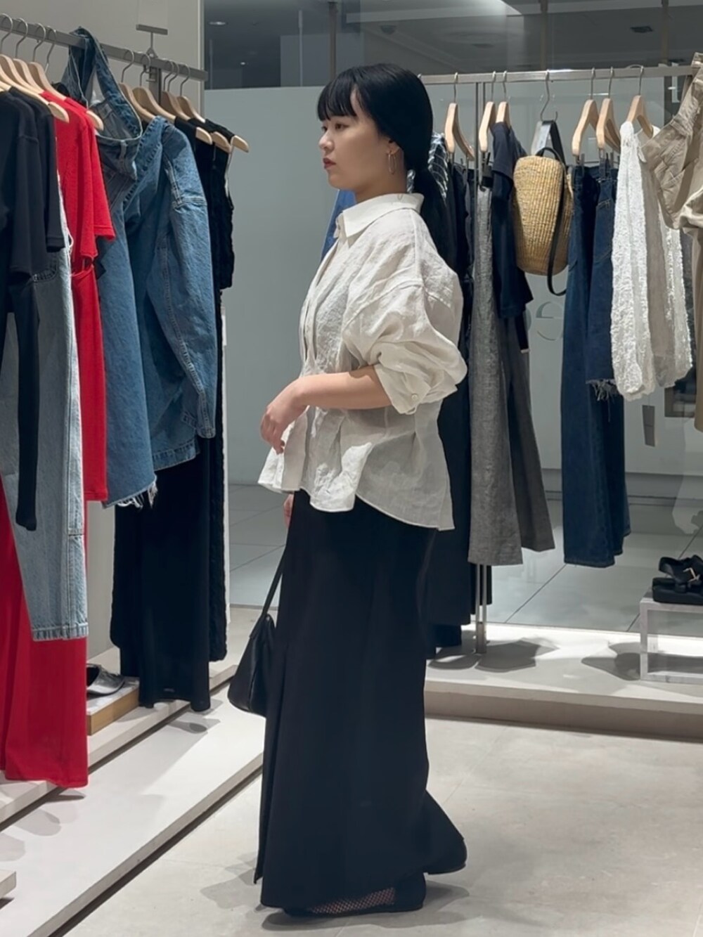 ホワイト系のシャツ/ブラウス、ブラック系のスカート、ブラック系のトートバッグを着用したレディースの春コーディネートの4枚目の写真