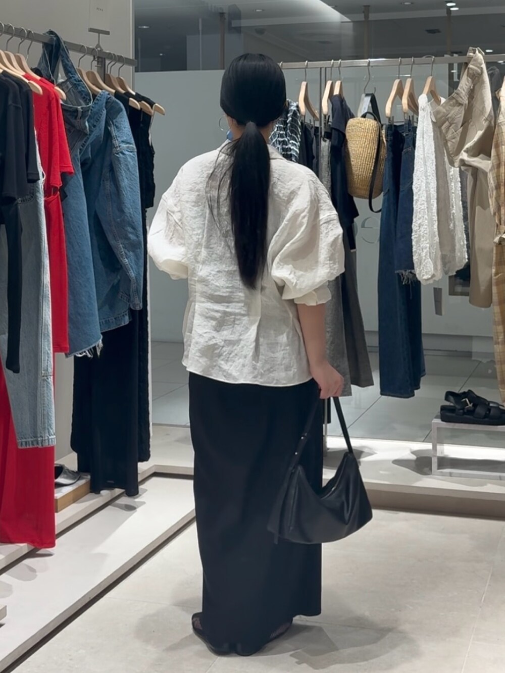 ホワイト系のシャツ/ブラウス、ブラック系のスカート、ブラック系のトートバッグを着用したレディースの春コーディネートの5枚目の写真
