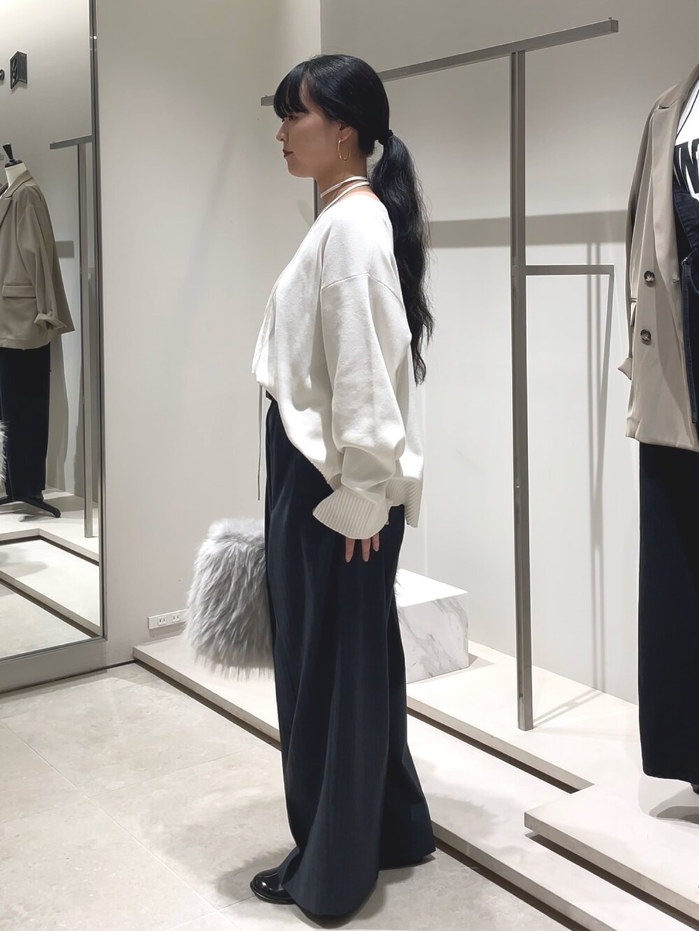 ブルー系のその他パンツ、ホワイト系のニット/セーター、ブラック系のブーツを着用したレディースの秋コーディネートの4枚目の写真