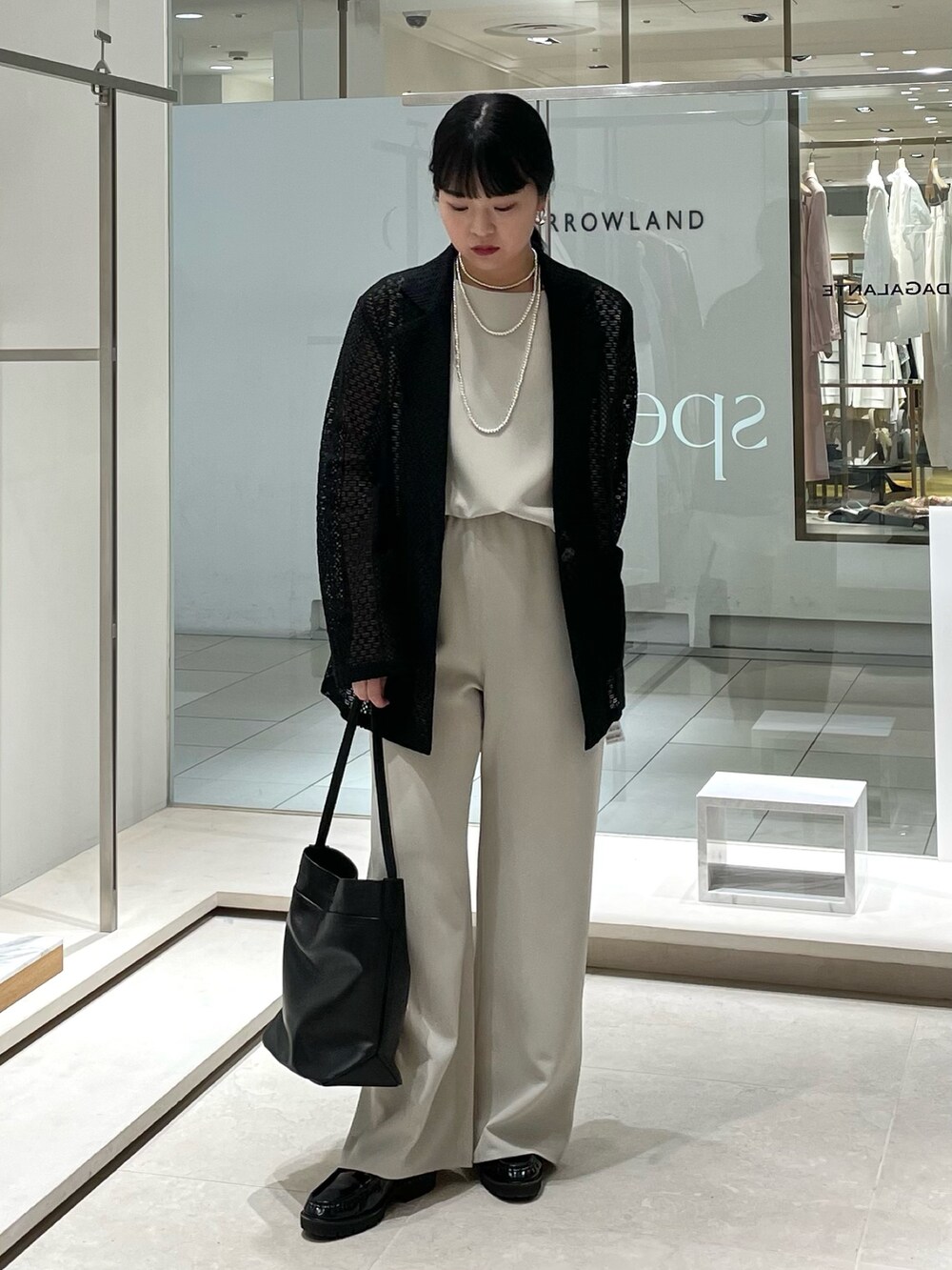 ベージュ系のその他パンツ、ブラック系のトートバッグ、ベージュ系のシャツ/ブラウスを着用したレディースの春コーディネートの2枚目の写真