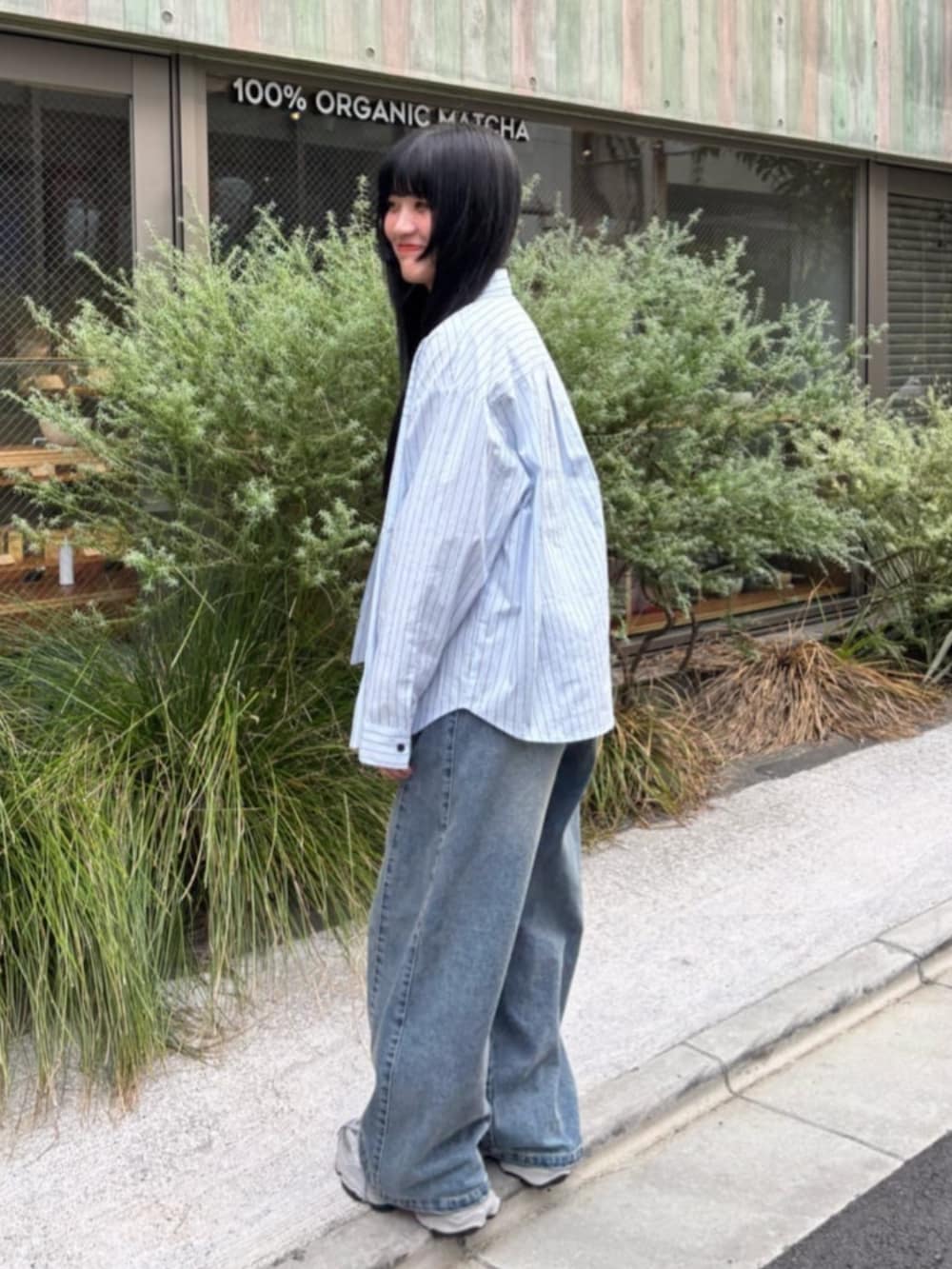 シルバー系のスニーカー、ブルー系のシャツ/ブラウス、ブラック系のキャミソールを着用したレディースの秋コーディネートの2枚目の写真