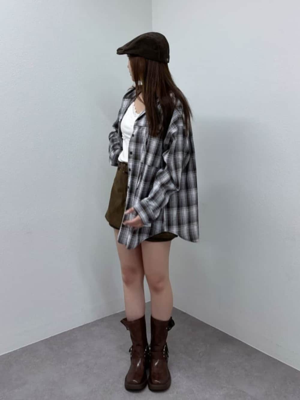 ホワイト系のキャミソール、ブラウン系のスカート、ブラウン系のブーツを着用したレディースの秋コーディネートの2枚目の写真