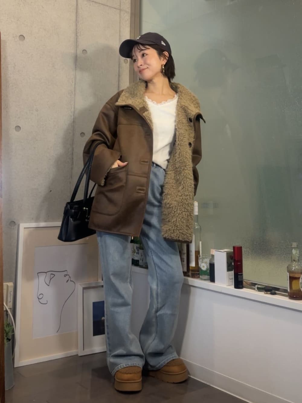 イエロー系のブーツ、ブラウン系のムートンコートを着用したレディースの秋コーディネートの2枚目の写真