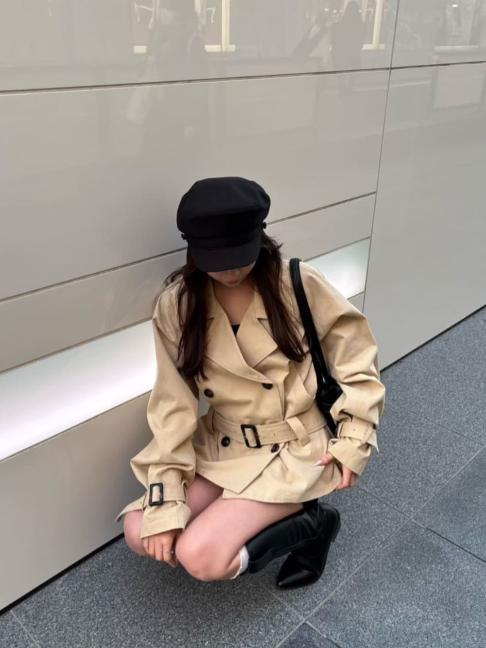 ベージュ系のトレンチコートを着用したレディースの冬コーディネートの3枚目の写真