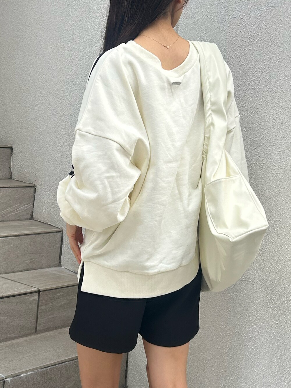 ホワイト系のスウェット、ブラック系のその他パンツを着用したレディースの秋コーディネートの2枚目の写真