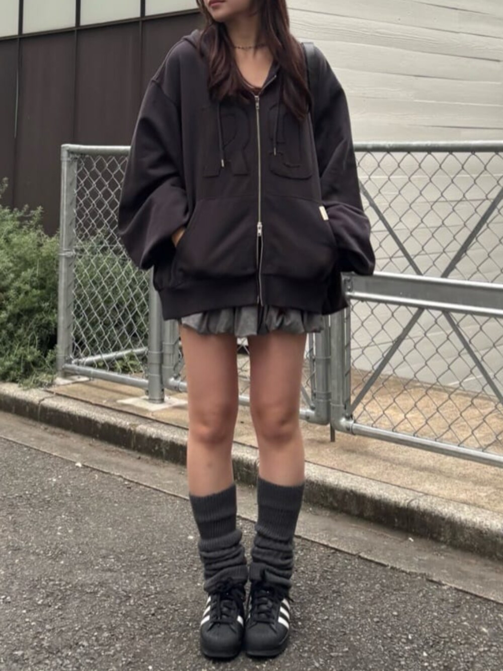 グレー系のパーカー、グレー系のスカート、グレー系のレッグウォーマーを着用したレディースの秋コーディネートの2枚目の写真