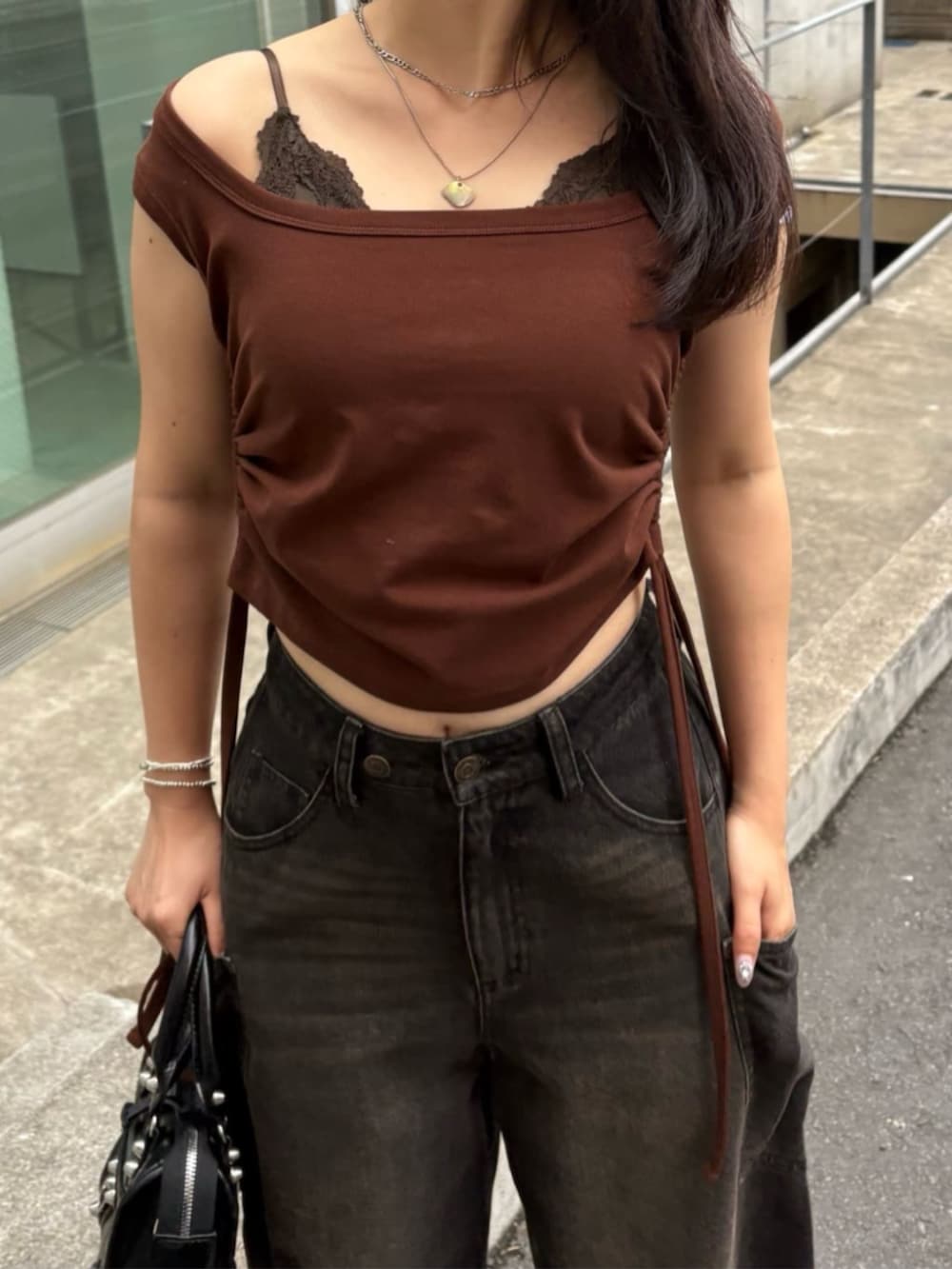 ブラック系のデニムパンツ、ブラウン系のTシャツ/カットソーを着用したレディースの夏コーディネートの2枚目の写真