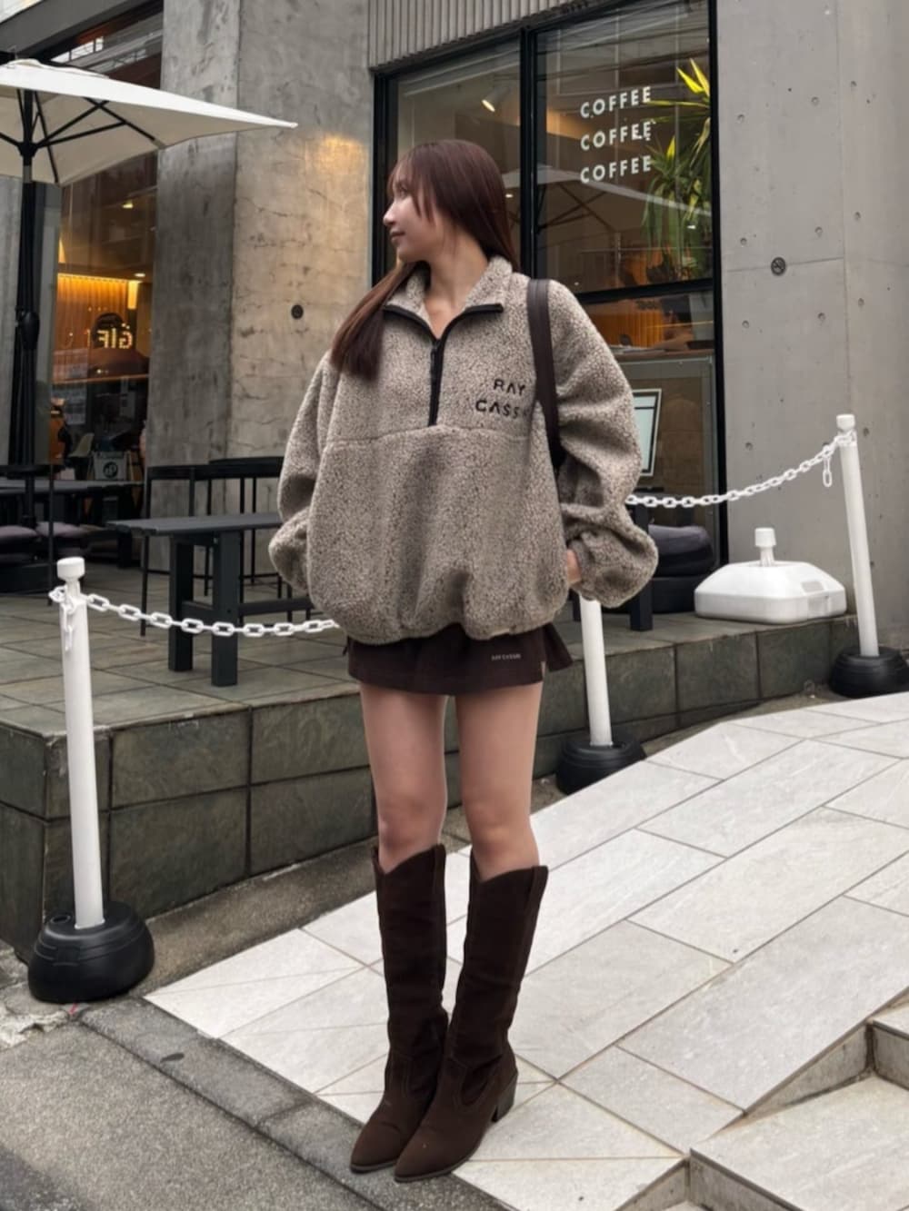 ブラウン系のブーツ、ベージュ系のスウェット、ブラウン系のスカートを着用したレディースの冬コーディネートの2枚目の写真